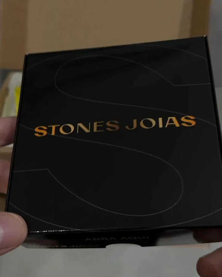 Caixa preta com o nome Stones Joias em dourado